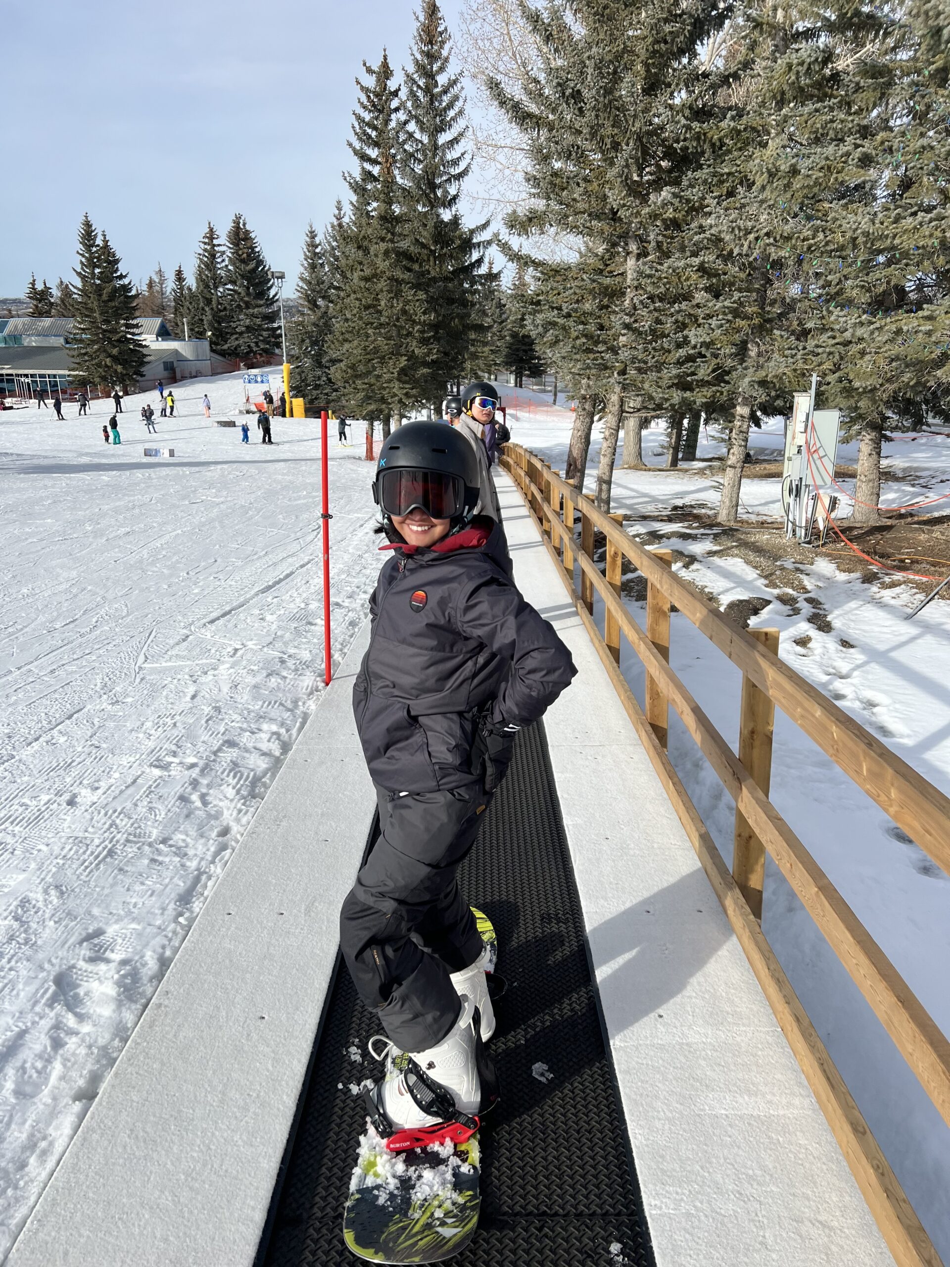 Eartha wearing snowboard overalls, a jacket, and goggles from Decathlon